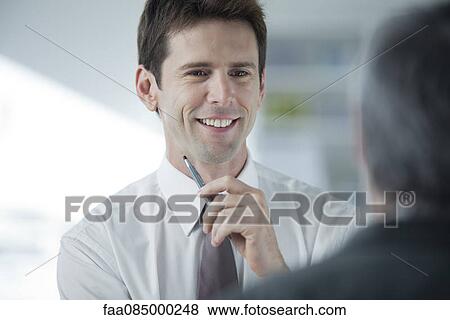 Businessman talking to colleague View Large Photo Image Stock Photo - Businessman talking to colleague. Fotosearch
