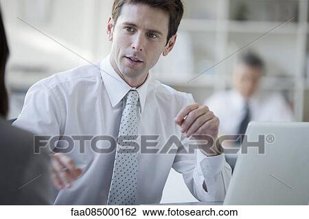 Businessman talking with colleague View Large Photo Image Stock Image - Businessman talking with colleague. Fotosearch