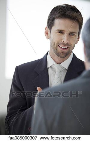 Stock Photo - Businessman talking with colleague. Fotosearch