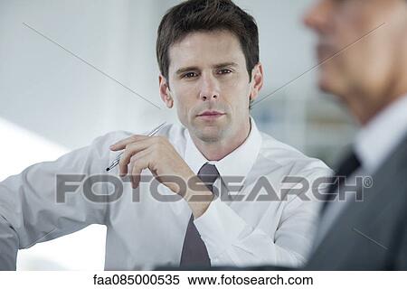 Businessman thinking during meeting View Large Photo Image Stock Photography - Businessman thinking during meeting. Fotosearch