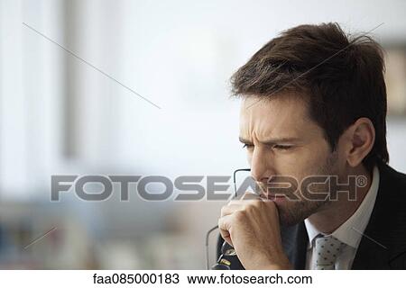 Stock Image - Businessman thinking with furrowed brow. Fotosearch