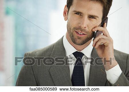 Stock Photo - Businessman using cell phone, portrait. Fotosearch