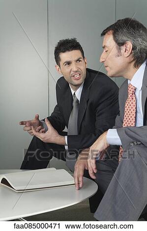 Stock Image - Businessmen discussing work. Fotosearch