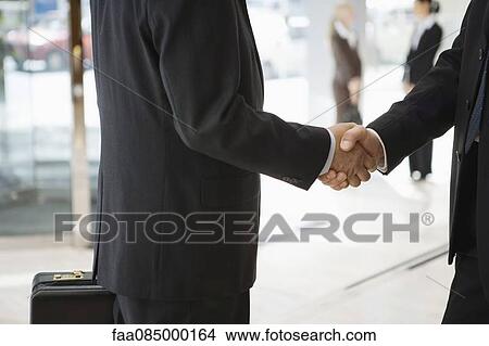 Businessmen shaking hands, cropped View Large Photo Image Picture - Businessmen shaking hands, cropped. Fotosearch