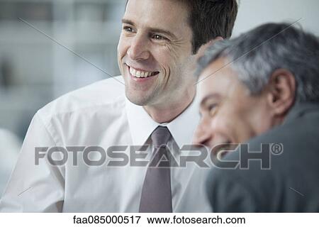 Businessmen smiling during meeting View Large Photo Image Stock Photo - Businessmen smiling during meeting. Fotosearch
