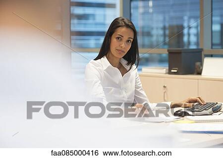 Stock Photograph - Businesswoman working in office. Fotosearch