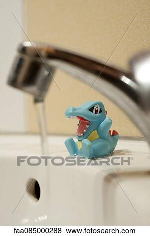 Child's toy sitting on side of bathtub, water running in foreground View Large Photo Image Stock Photo - Child's toy sitting on side of bathtub, water running in foreground. Fotosearch