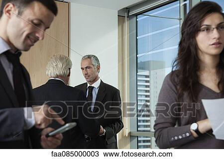 Stock Image - Colleagues collaborating in office. Fotosearch