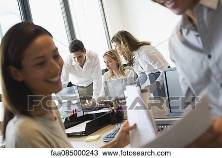 Colleagues collaborating in office View Large Photo Image Stock Image - Colleagues collaborating in office. Fotosearch