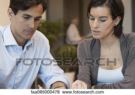 Stock Photo - Colleagues working together in office. Fotosearch
