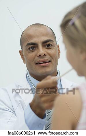 Stock Image - Doctor examining young patient. Fotosearch