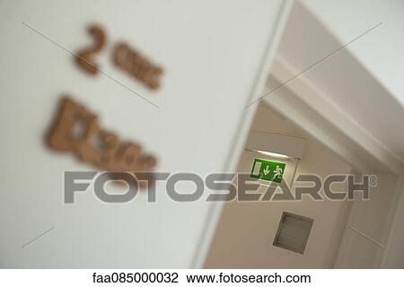 Stock Image - Emergency exit sign in corridor. Fotosearch