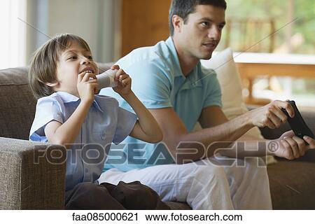 Father and son playing video game together View Large Photo Image Stock Image - Father and son playing video game together. Fotosearch