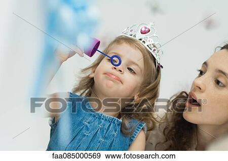 Stock Photo - Girl with tiara blowing bubbles. Fotosearch