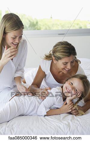 Stock Photograph - Grandmother, daughter and granddaughter relaxing together. Fotosearch