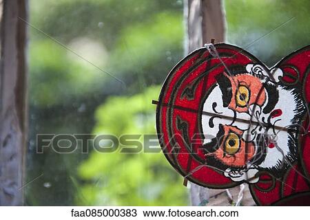 Stock Image - Homemade paper kite with menacing face. Fotosearch