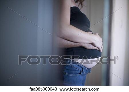Husband wrapping arms around pregnant wife, side view View Large Photo Image Stock Image - Husband wrapping arms around pregnant wife, side view. Fotosearch