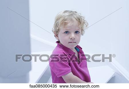 Stock Photography - Little boy biting lips, portrait. Fotosearch