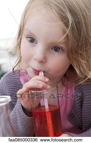 Stock Photograph - Little girl drinking beverage with straw. Fotosearch