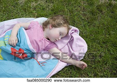 Stock Image - Little girl napping outdoors. Fotosearch
