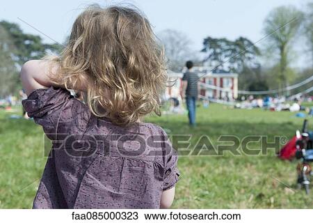 Stock Image - Little girl outdoors, rear view. Fotosearch