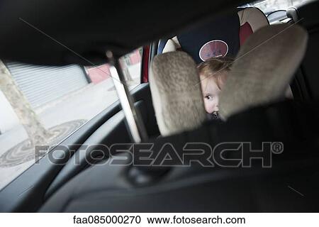 Stock Image - Little girl sitting in car seat. Fotosearch