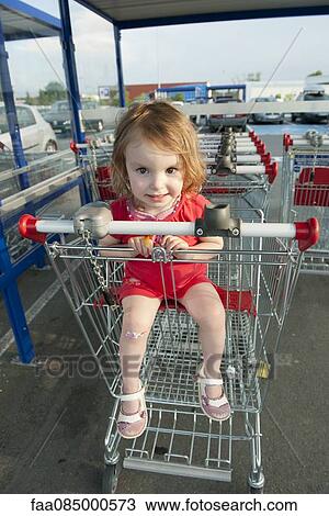 Little girl sitting in shopping cart View Large Photo Image Stock Image - Little girl sitting in shopping cart. Fotosearch