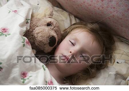Stock Photography - Little girl sleeping with teddy bear. Fotosearch