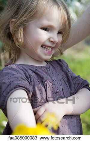 Stock Image - Little girl smiling outdoors. Fotosearch