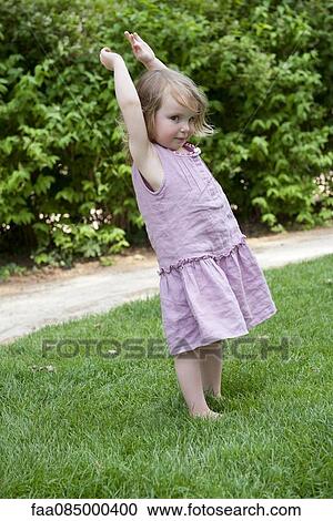 Little girl standing outdoors with arms raised View Large Photo Image Stock Image - Little girl standing outdoors with arms raised. Fotosearch