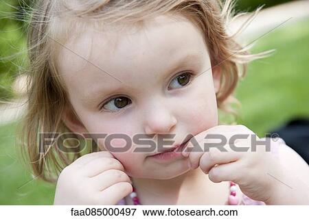 Little girl touching mouth, looking away in thought View Large Photo Image Stock Photo - Little girl touching mouth, looking away in thought. Fotosearch