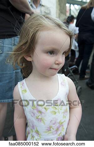 Stock Image - Little girl walking on sidewalk. Fotosearch