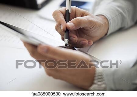 Stock Image - Man using digital tablet and stylus, cropped. Fotosearch