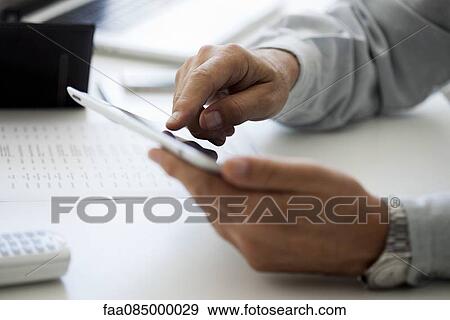 Stock Photo - Man using touch screen on digital tablet, cropped. Fotosearch