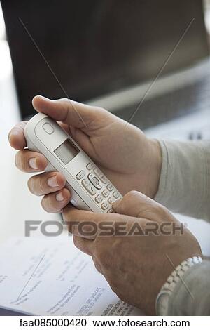 Man's hands holding cell phone, cropped View Large Photo Image Stock Image - Man's hands holding cell phone, cropped. Fotosearch