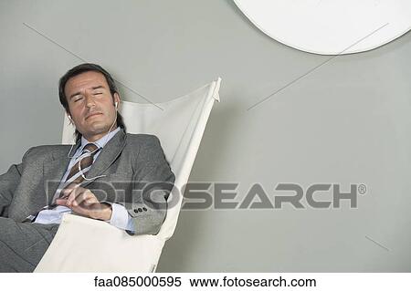 Mature business executive listening to music with earphones View Large Photo Image Stock Photography - Mature business executive listening to music with earphones. Fotosearch