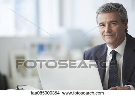 Mature businessman smiling in office, portrait View Large Photo Image Picture - Mature businessman smiling in office, portrait. Fotosearch