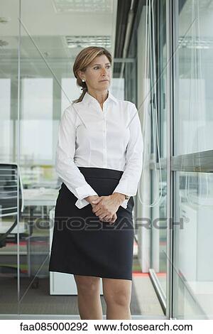 Mature businesswoman looking out window View Large Photo Image Stock Image - Mature businesswoman looking out window. Fotosearch