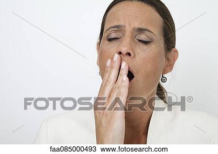 Stock Image - Mature woman yawning. Fotosearch