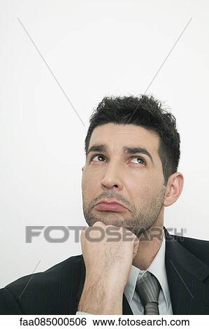 Stock Photograph - Mid-adult businessman contemplating. Fotosearch