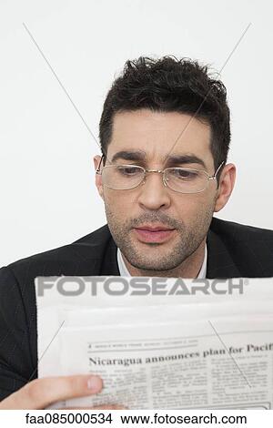 Mid-adult businessman reading newspaper View Large Photo Image Picture - Mid-adult businessman reading newspaper. Fotosearch
