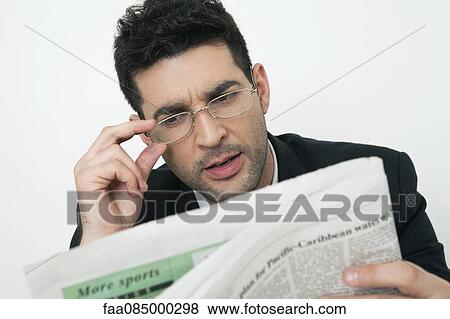 Mid-adult businessman reading newspaper View Large Photo Image Stock Photo - Mid-adult businessman reading newspaper. Fotosearch