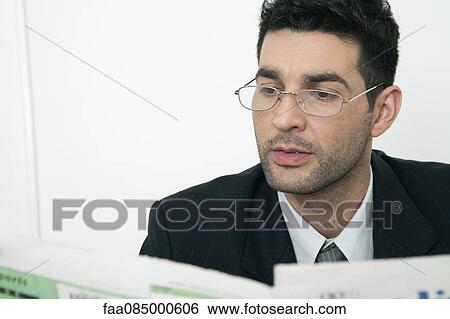Mid-adult businessman reading newspaper View Large Photo Image Stock Photograph - Mid-adult businessman reading newspaper. Fotosearch