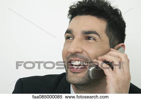 Mid-adult businessman talking on cell phone, smiling View Large Photo Image Stock Photography - Mid-adult businessman talking on cell phone, smiling. Fotosearch