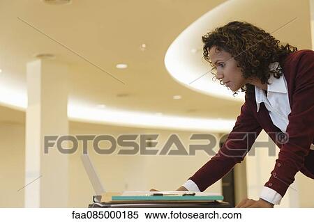 Mid-adult businesswoman working on laptop computer View Large Photo Image Stock Photography - Mid-adult businesswoman working on laptop computer. Fotosearch