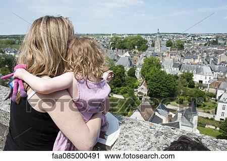 Stock Image - Mother and young daughter looking at view of Vendome, France. Fotosearch
