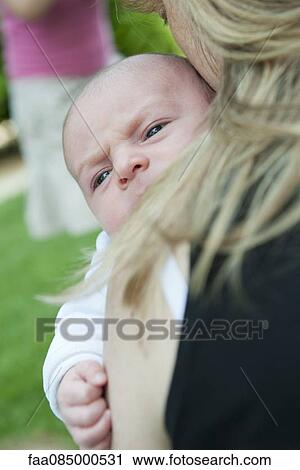 Stock Image - Mother carrying infant, cropped. Fotosearch