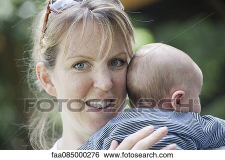 Mother holding baby, smiling View Large Photo Image Stock Photograph - Mother holding baby, smiling. Fotosearch