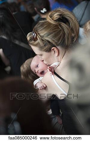 Mother kissing infant's cheek View Large Photo Image Stock Photograph - Mother kissing infant's cheek. Fotosearch
