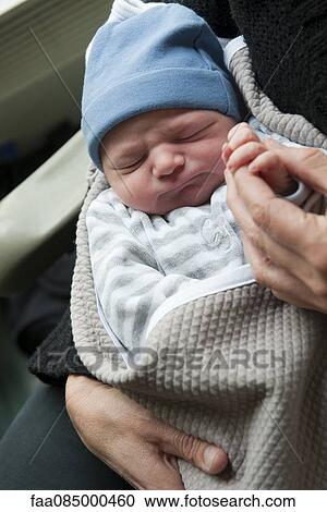Stock Image - Newborn baby holding adult's finger. Fotosearch